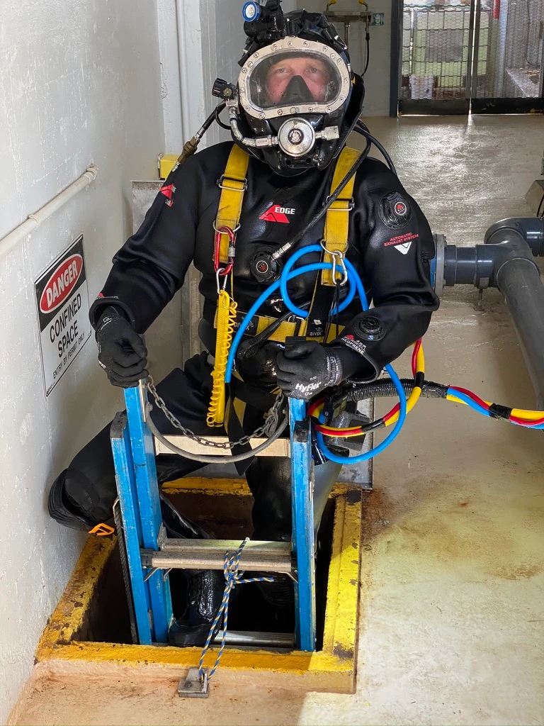 Fire Tanks Australia diver in full gear, preparing to enter a confined space through a ladder for water tank maintenance and inspection.