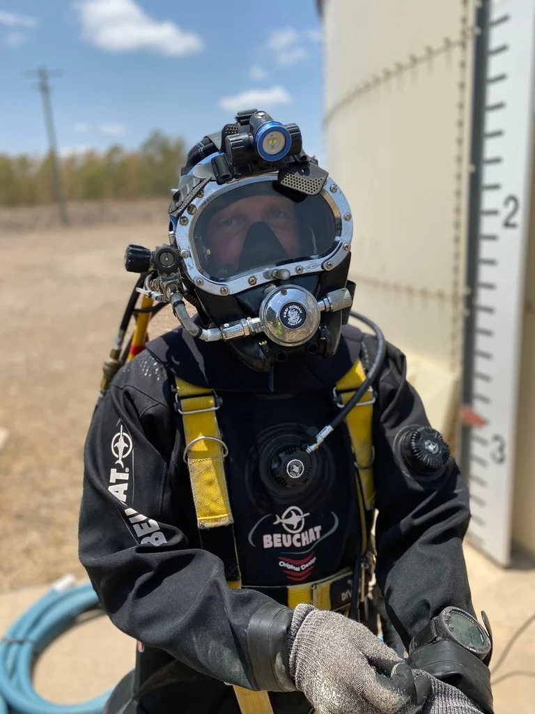Fire Tanks Australia diver in full protective gear and helmet preparing for an underwater fire tank inspection.