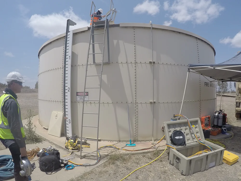 Fire Tanks Australia team conducting maintenance and inspection on a large above-ground fire water tank.
